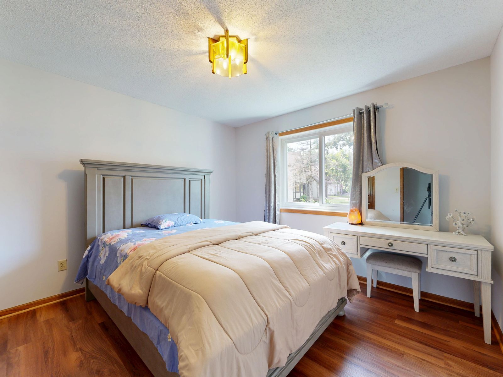 A practical bedside table with lamp book and water in a lived-in bedroom