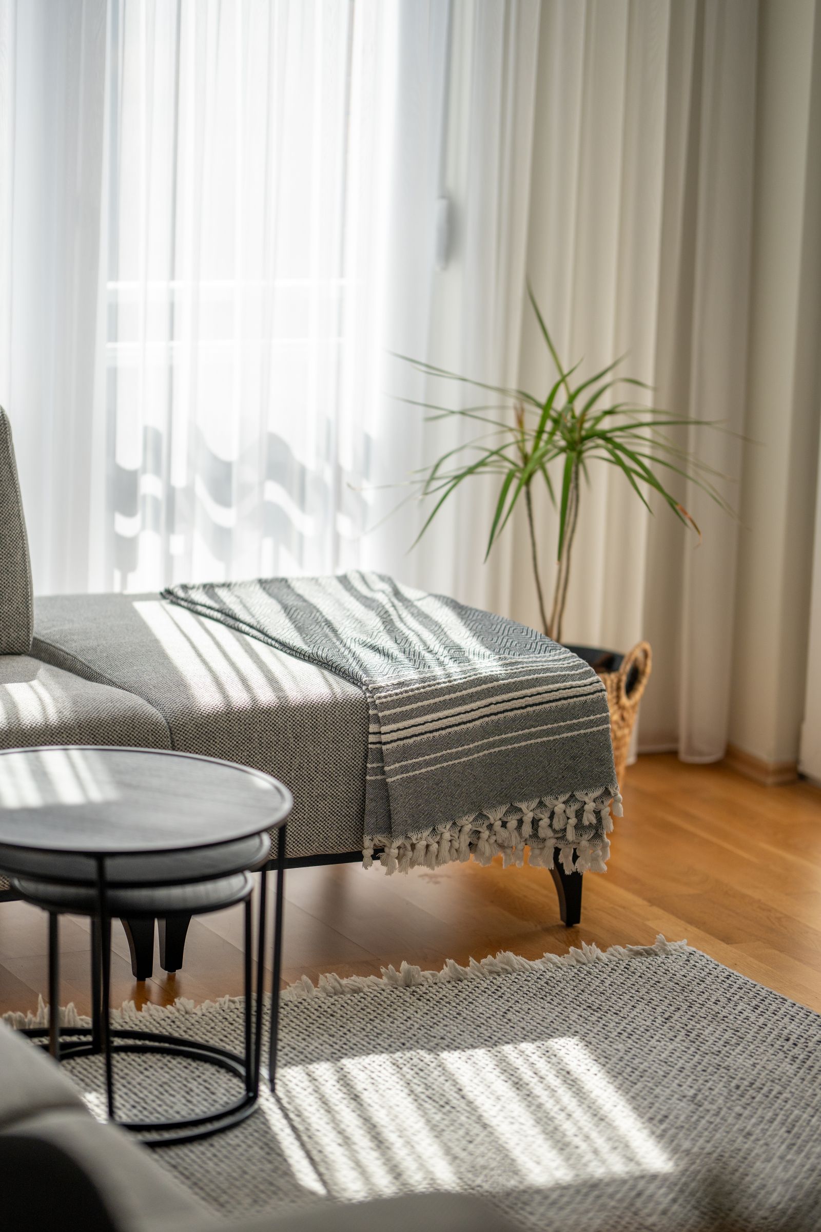 A warm table lamp lighting a lived-in living room reading corner