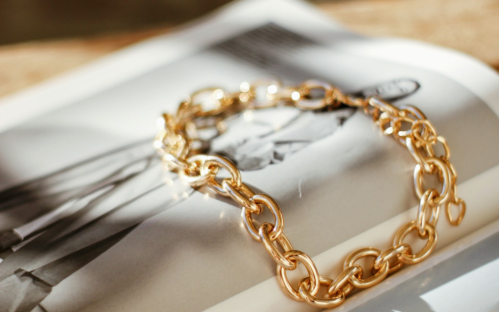 Gold-toned everyday necklaces and bracelets arranged on a dressing table