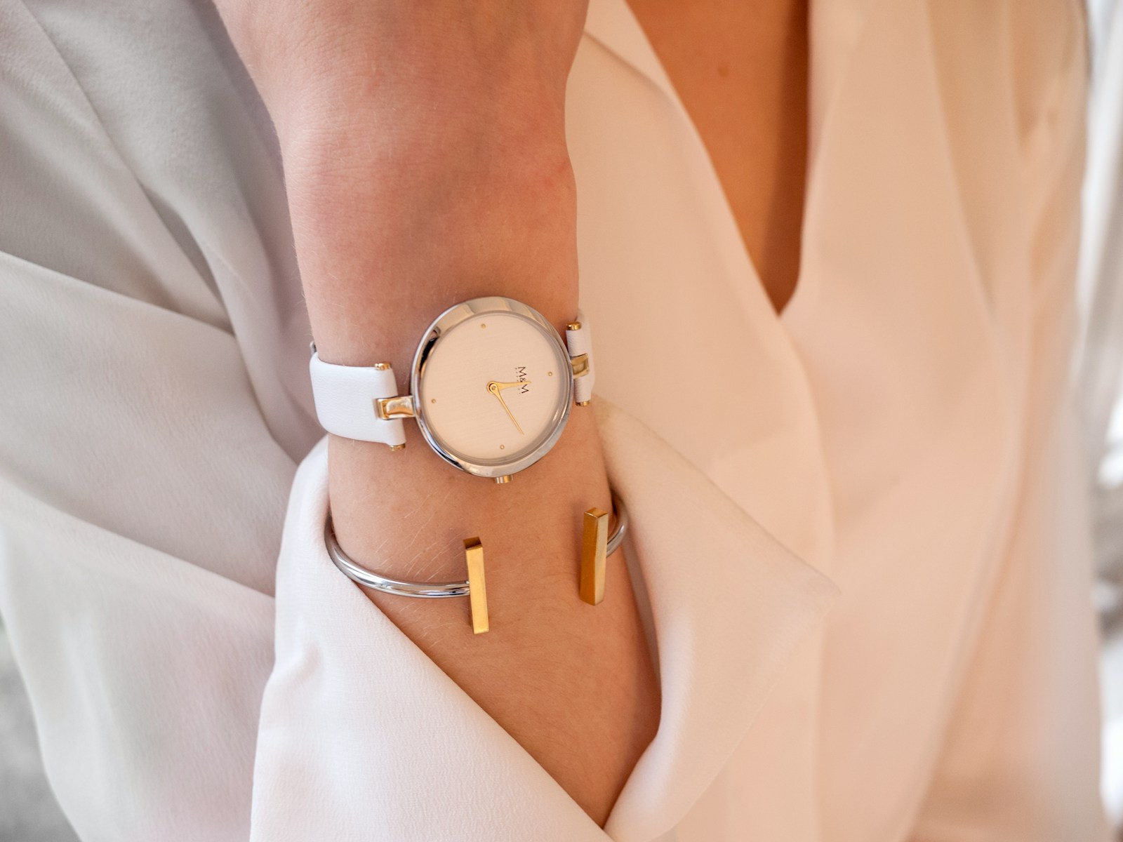 A natural close-up of a woman wearing a watch and simple bracelets