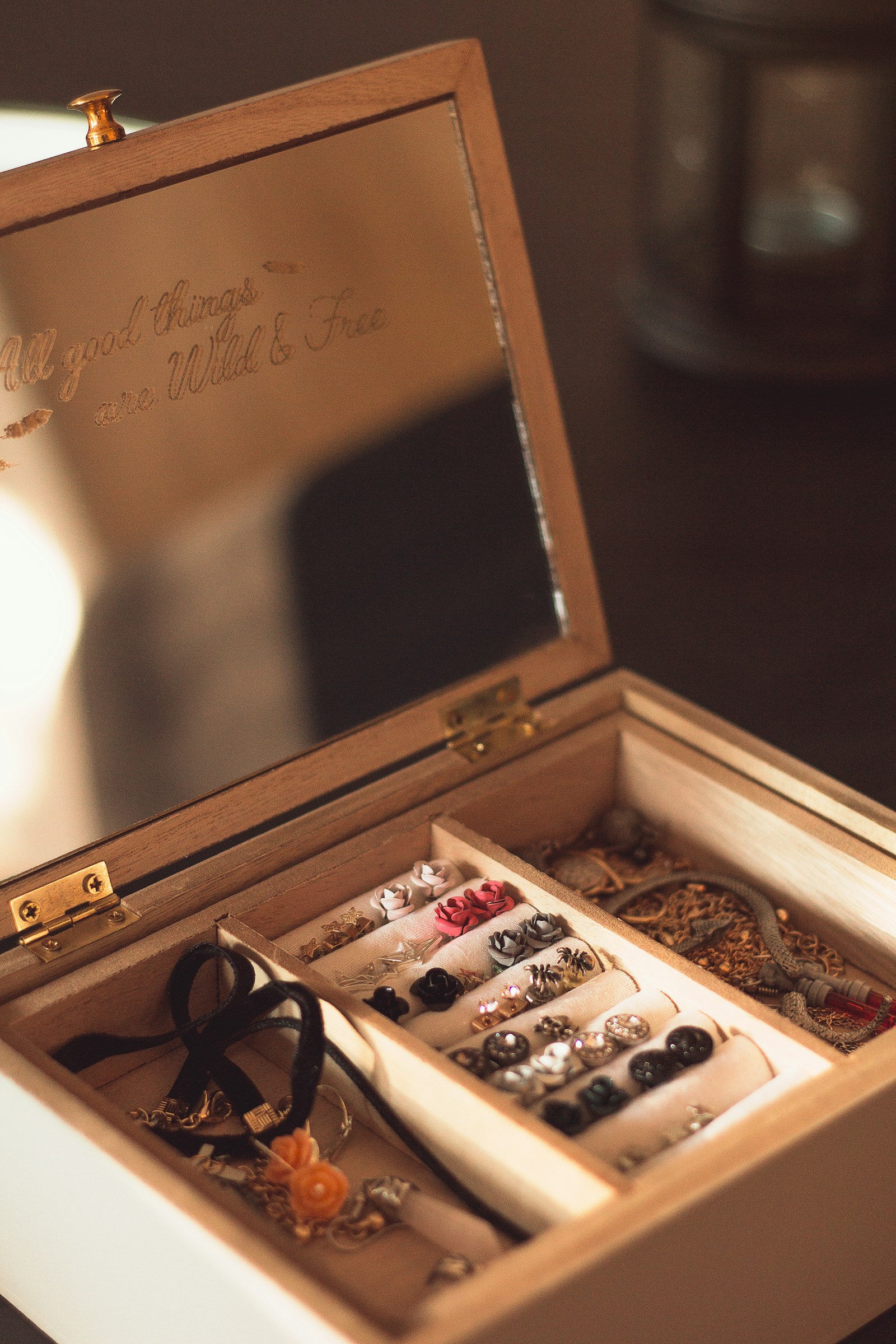 A compact jewelry travel case being packed beside clothing for a weekend trip